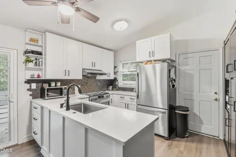 a kitchen with stainless steel appliances a refrigerator sink and cabinets