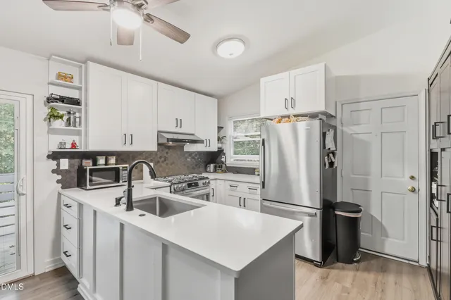 a kitchen with stainless steel appliances a refrigerator sink and cabinets