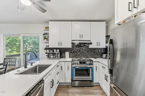 a kitchen with stainless steel appliances a stove sink and refrigerator