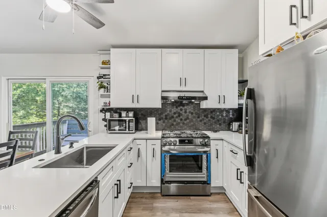 a kitchen with stainless steel appliances a stove sink and refrigerator