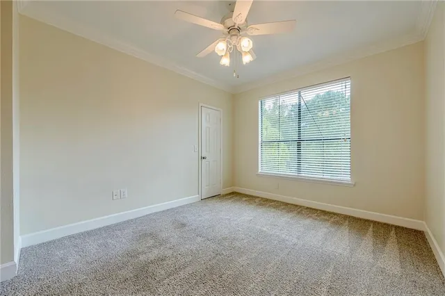 an empty room with windows and fan