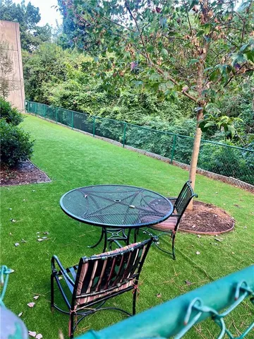 a view of a backyard with table and chairs under an umbrella