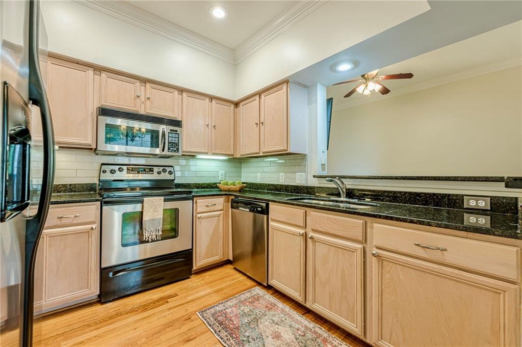 3777 Peachtree Road Northeast, Unit 1632 Brookhaven, GA 30319 - Photo 5 of 43 a kitchen with granite countertop a sink stainless steel appliances and cabinets