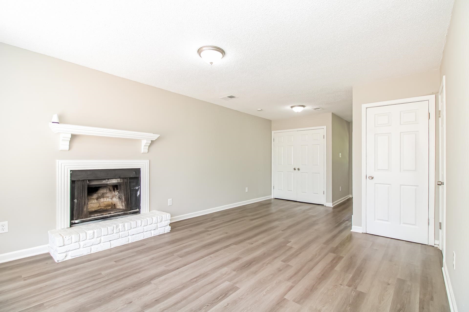 3546 Christine Road Memphis, TN 38118 - Photo 4 of 23 a view of an empty room with wooden floor fireplace and a window