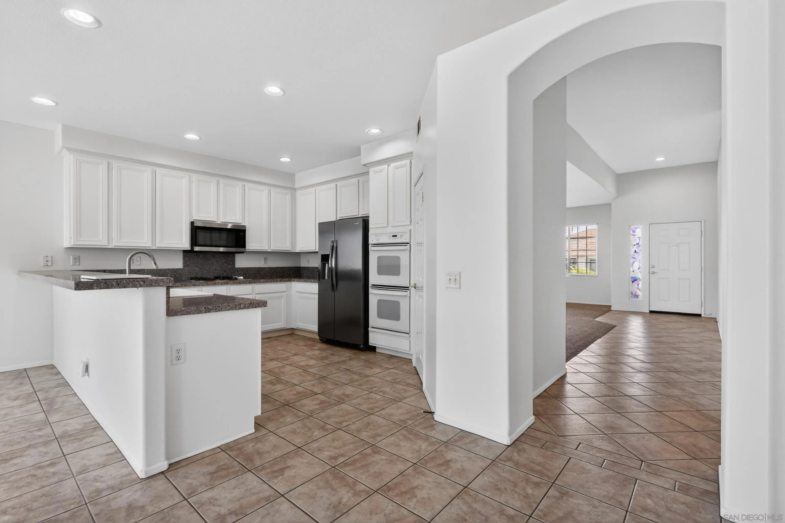 1432 Belmont Park Road Oceanside, CA 92057 - Photo 18 of 54 a kitchen with white cabinets and stainless steel appliances