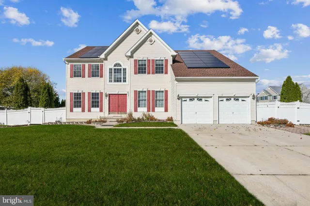 a view of a yard in front of a house with a large tree