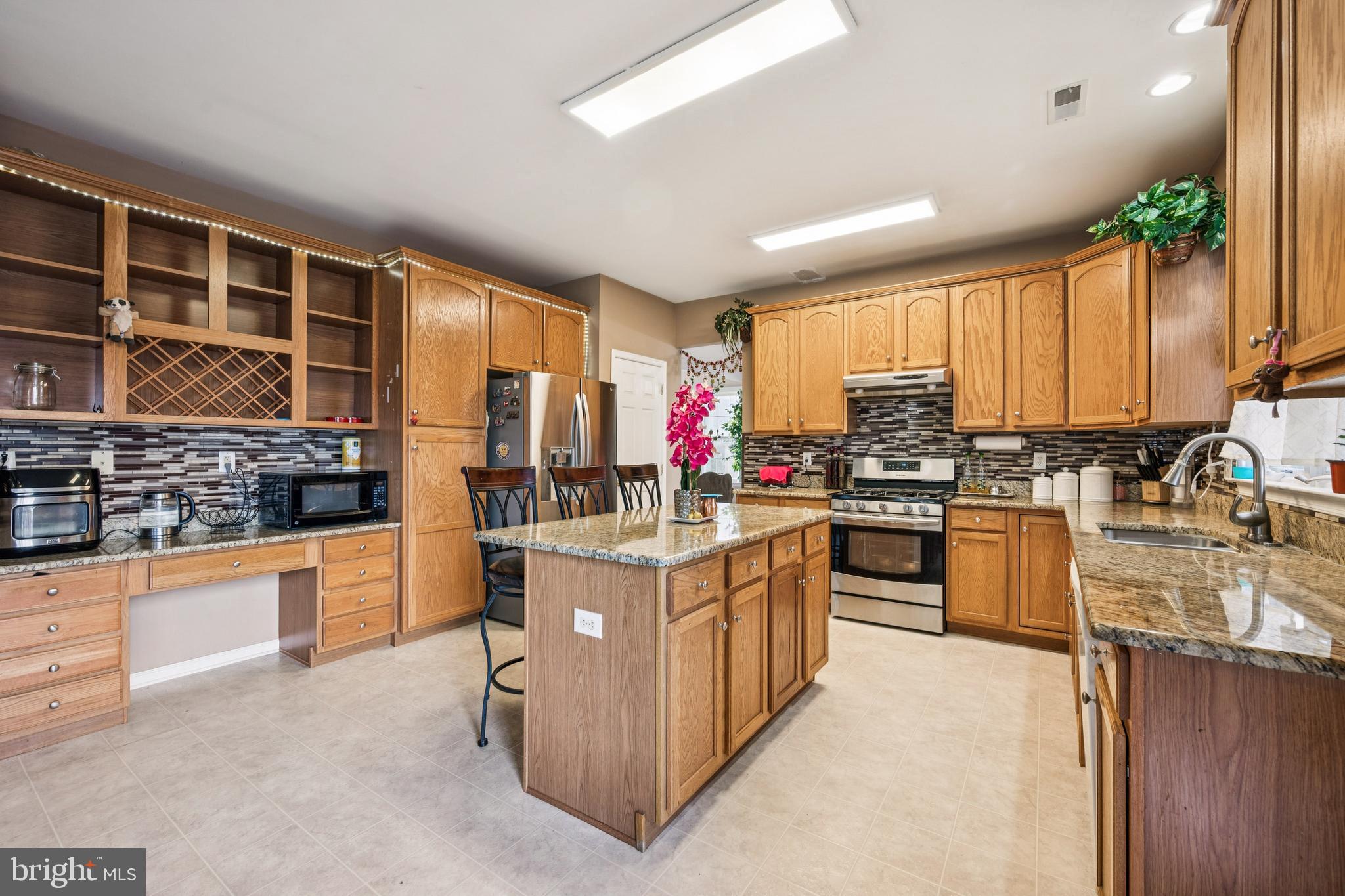 17 Jasmine Way Sewell, NJ 08080 - Photo 3 of 30 a kitchen with stainless steel appliances granite countertop a stove top oven a sink dishwasher a dining table and chairs with wooden floor