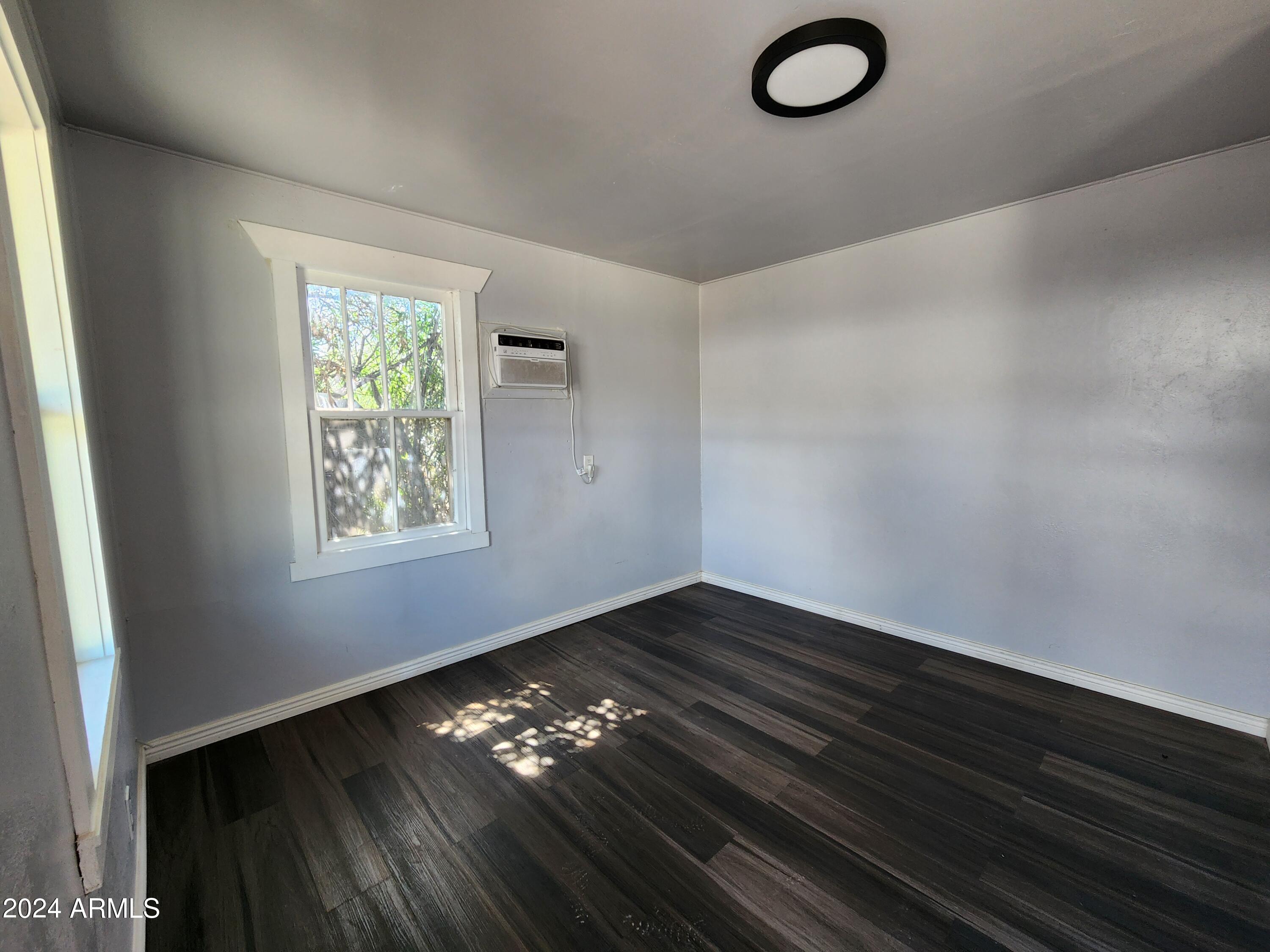 9028 North 11th Street, Unit 3 Phoenix, AZ 85020 - Photo 2 of 7 an empty room with wooden floor and windows