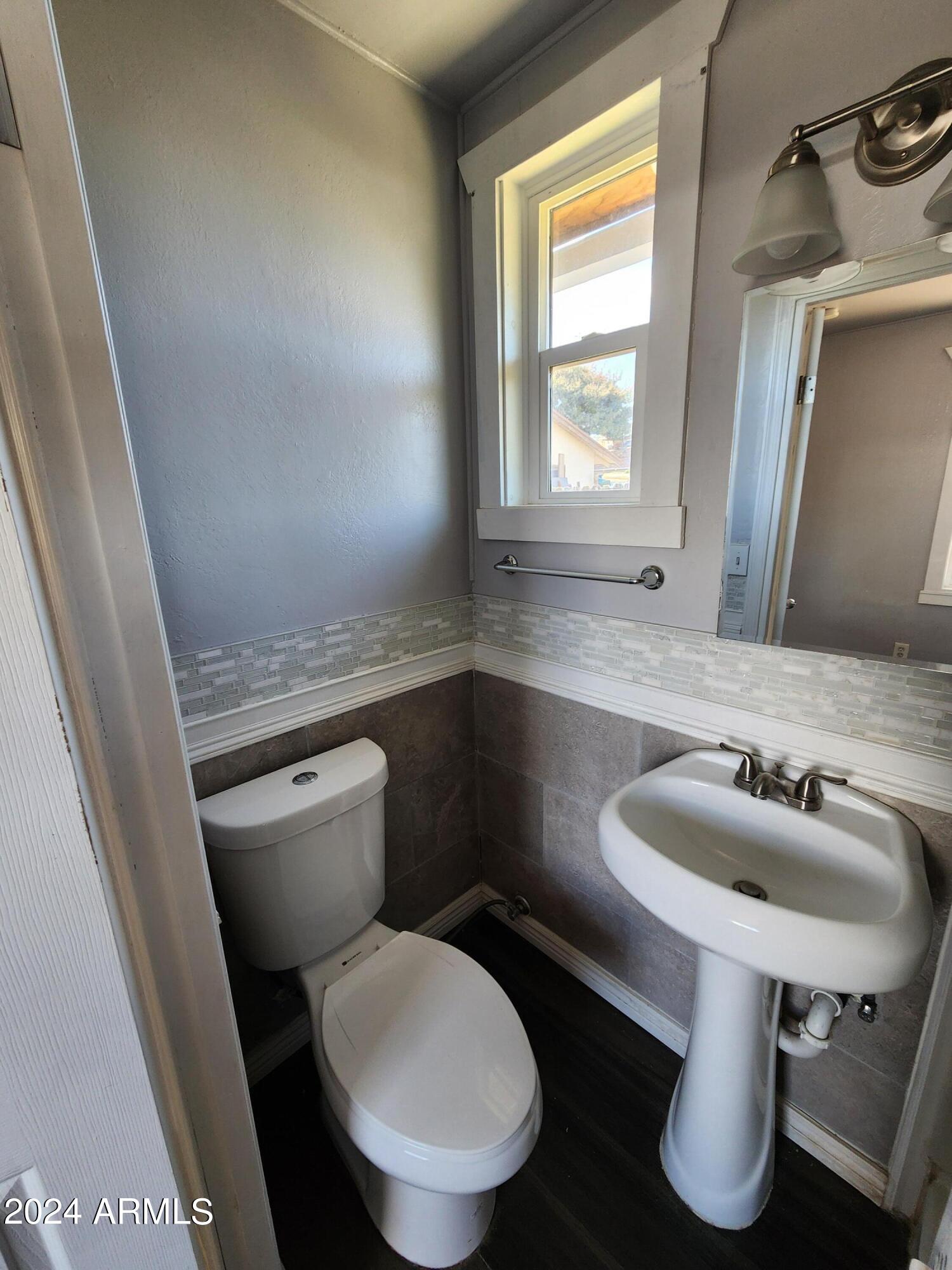 9028 North 11th Street, Unit 3 Phoenix, AZ 85020 - Photo 4 of 7 a bathroom with a toilet sink and mirror