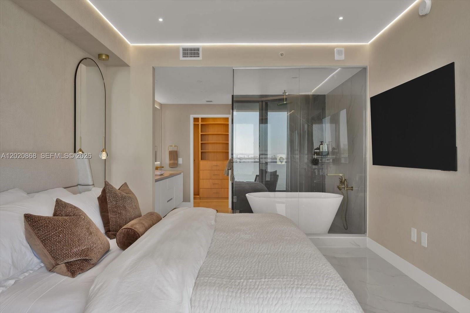 700 Northeast 24th Street, Unit 1602 Miami, FL 33137 - Photo 26 of 30 a bedroom with a large bed and a flat screen tv
