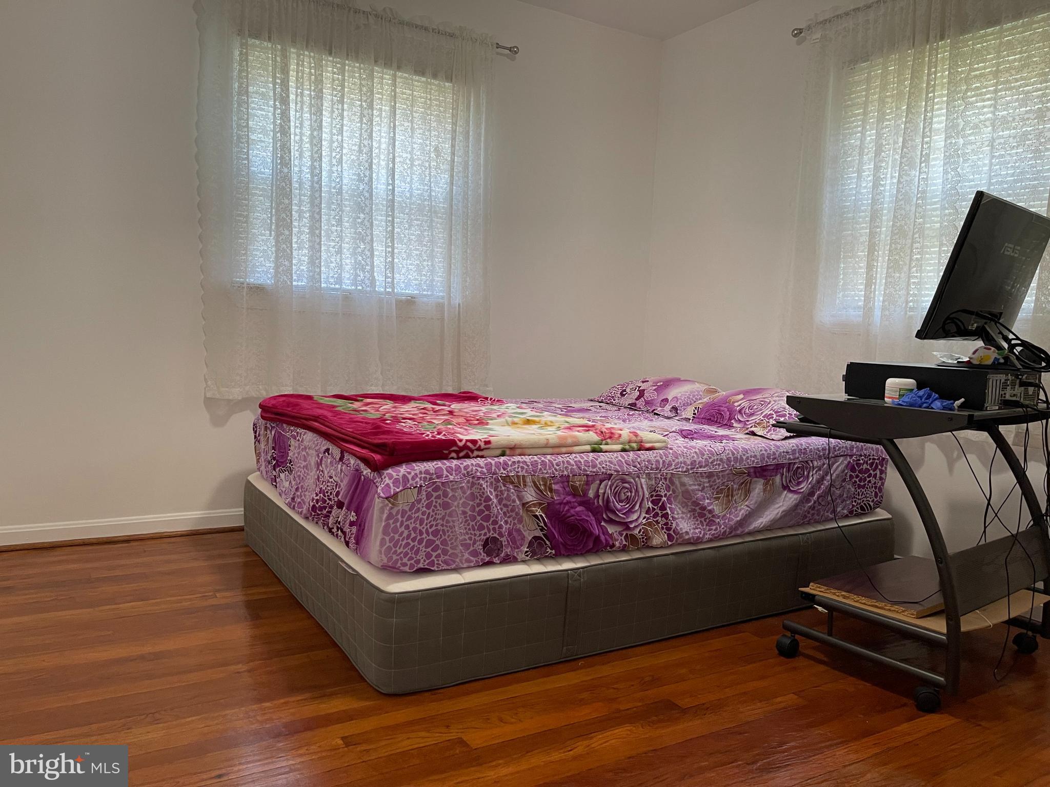 12306 Veirs Mill Road Silver Spring, MD 20906 - Photo 13 of 45 a bedroom with a bed and wooden floor