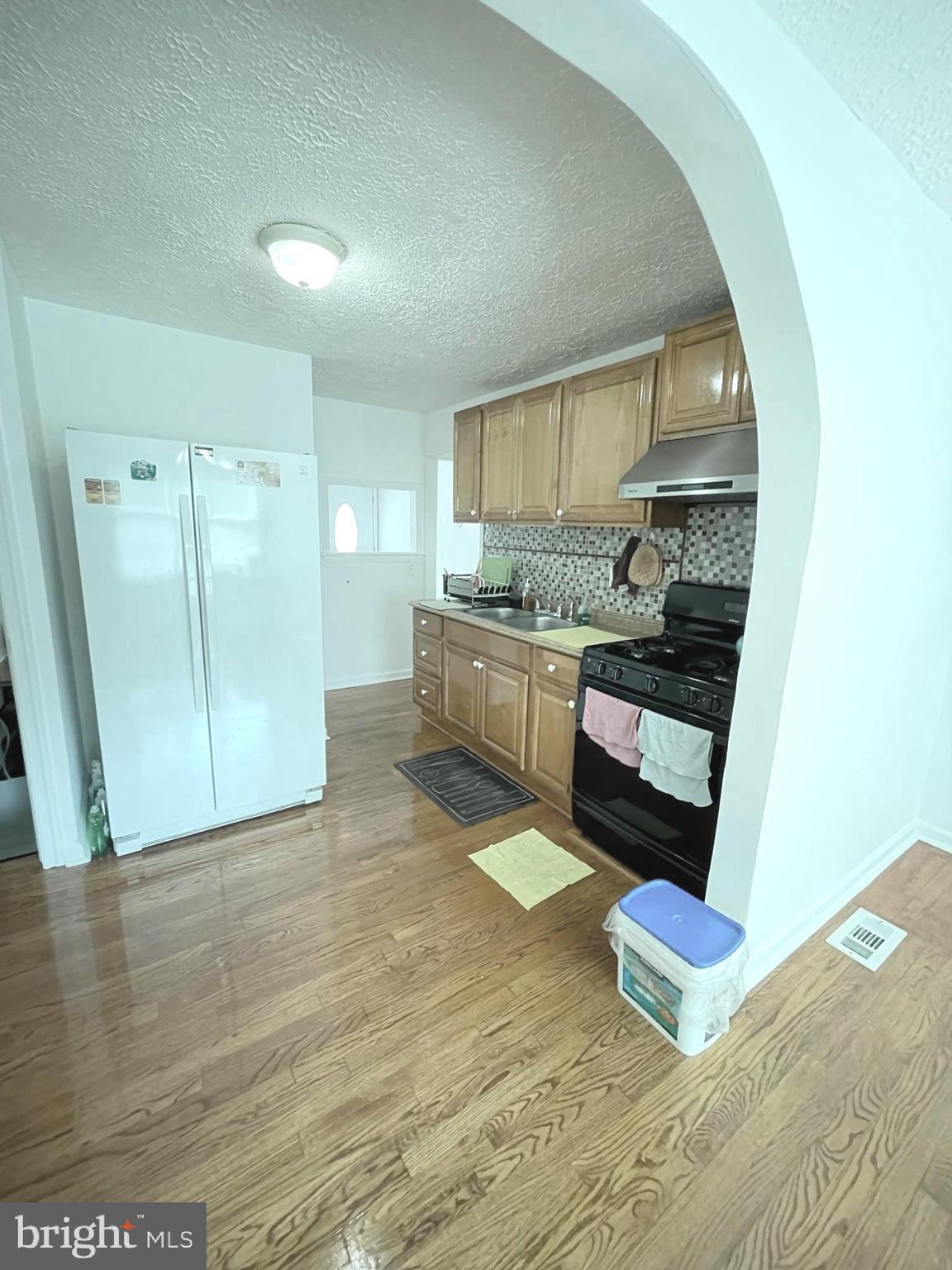 12306 Veirs Mill Road Silver Spring, MD 20906 - Photo 42 of 45 a living room with stainless steel appliances furniture a rug and a kitchen view