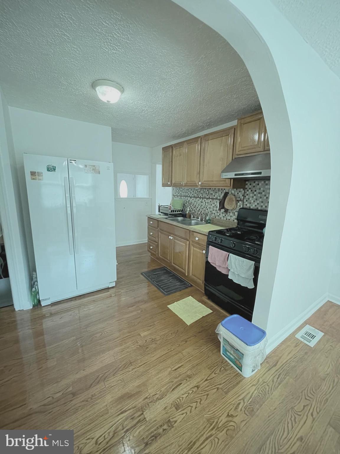 12306 Veirs Mill Road Silver Spring, MD 20906 - Photo 43 of 45 a living room with stainless steel appliances furniture a rug and a kitchen view