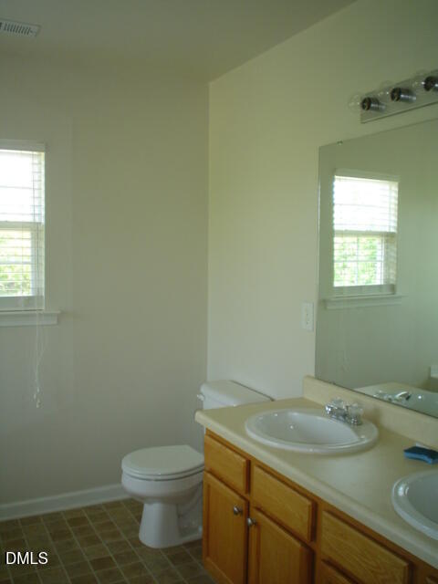 6005 Namozine Court Raleigh, NC 27610 - Photo 7 of 8 a bathroom with a granite countertop sink and a toilet