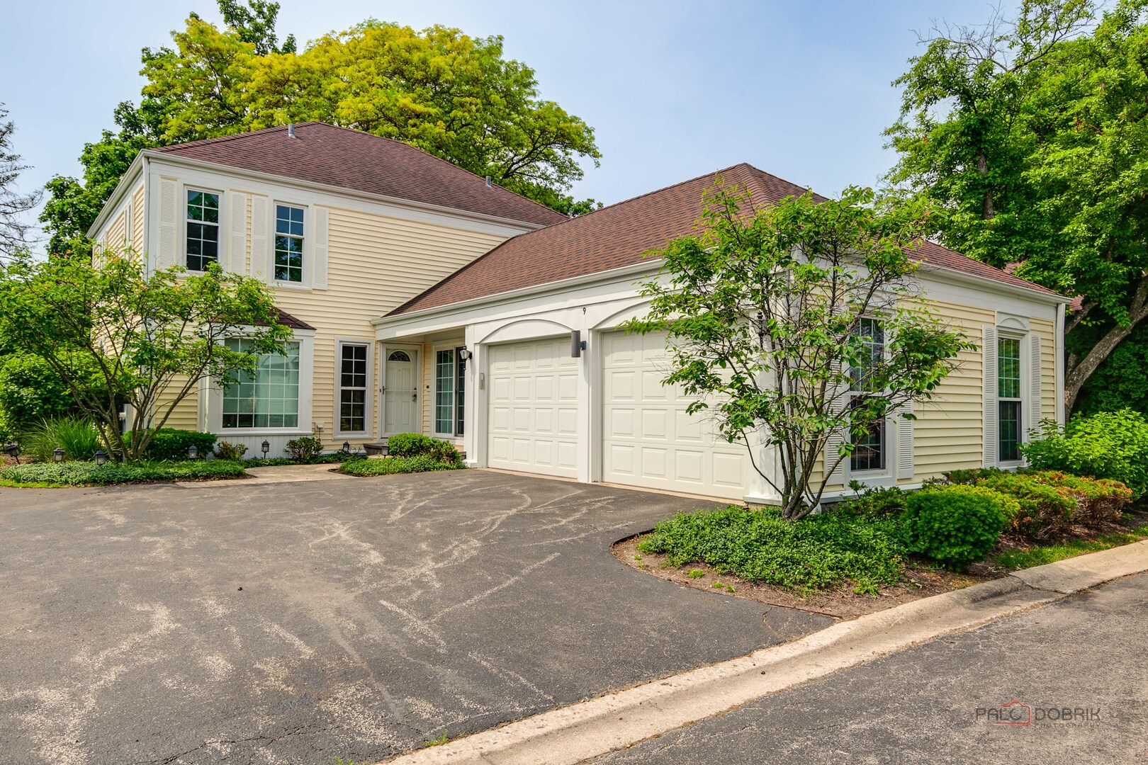 a front view of a house with a yard and a garage