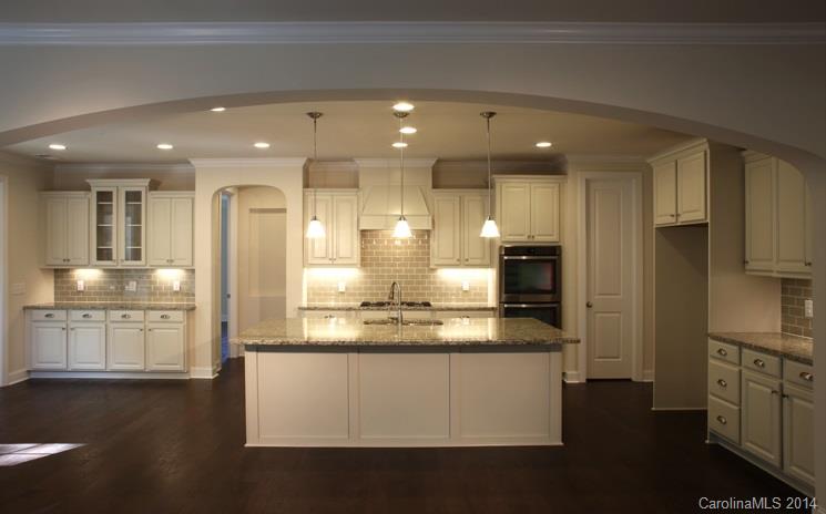 654 Chase Court, Unit 130 Fort Mill, SC 29708 - Photo 3 of 9 a large kitchen with stainless steel appliances kitchen island granite countertop a large cabinets a sink and a stove