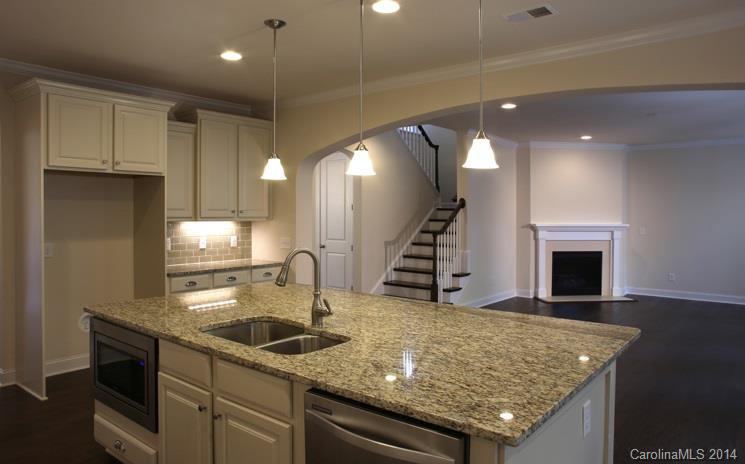 654 Chase Court, Unit 130 Fort Mill, SC 29708 - Photo 5 of 9 a kitchen with stainless steel appliances granite countertop a sink a stove and a wooden floors