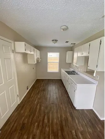 a kitchen with wooden floors and white appliances