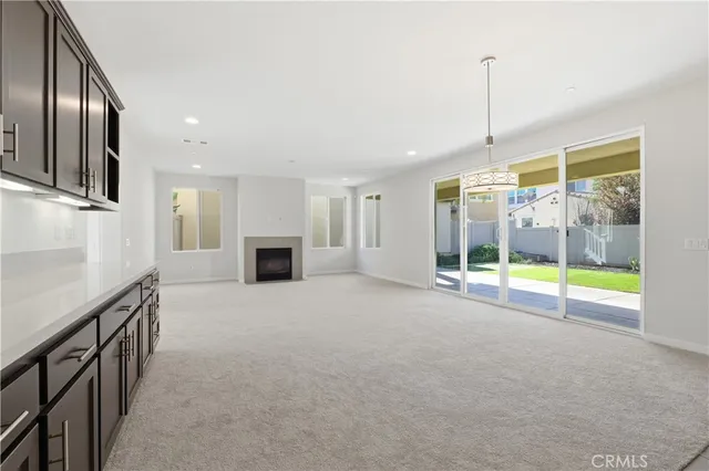 a view of an empty room with a fireplace and a window