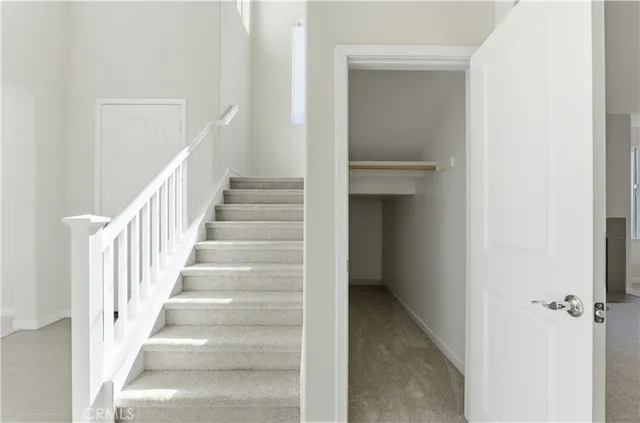 a view of a hallway with white walls and entryway