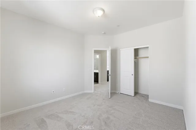 an empty room with closet and a bathroom