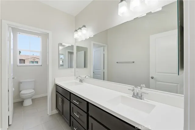 a bathroom with a double vanity sink mirror and toilet