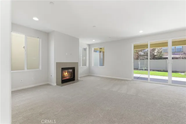 a view of an empty room with a fireplace and a window