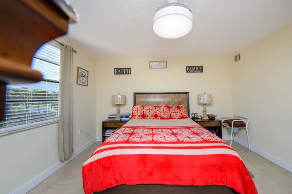 a bedroom with a bed and a potted plant