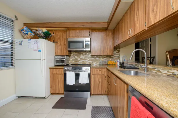 a kitchen with stainless steel appliances granite countertop a refrigerator sink and stove