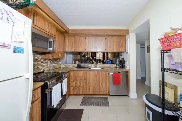 a kitchen with stainless steel appliances granite countertop a stove a sink and a refrigerator