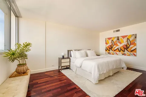 a bedroom with bed and a potted plant