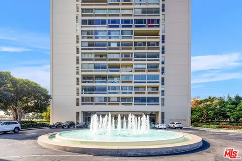 a view of a tall building next to a yard
