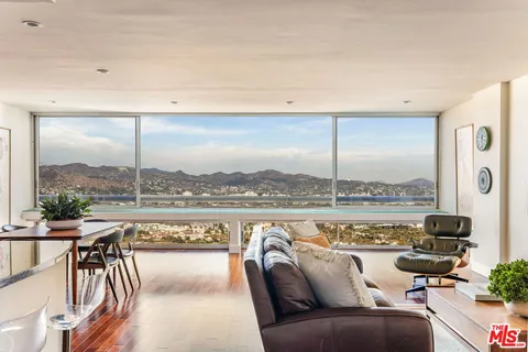 a balcony with furniture and a floor to ceiling window