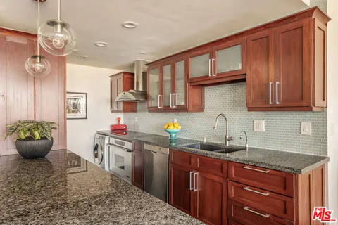 a kitchen with stainless steel appliances granite countertop a sink dishwasher stove and cabinets