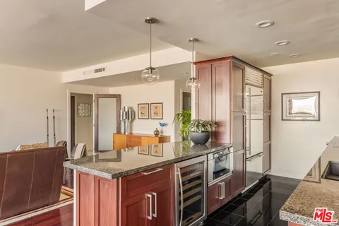 a kitchen that has a lot of cabinets and wooden floor