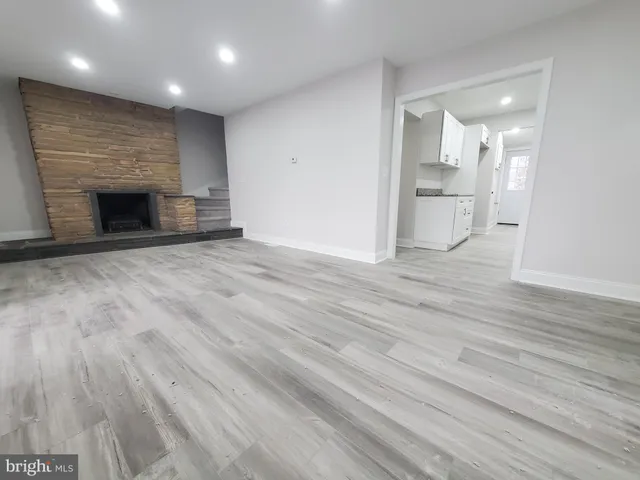 a view of empty room with wooden floor and fireplace