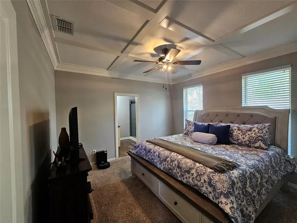 a bedroom with a large bed and a chandelier