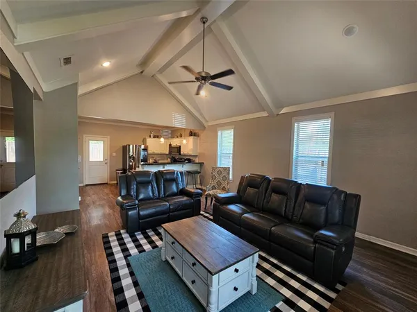 a living room with furniture and wooden floor