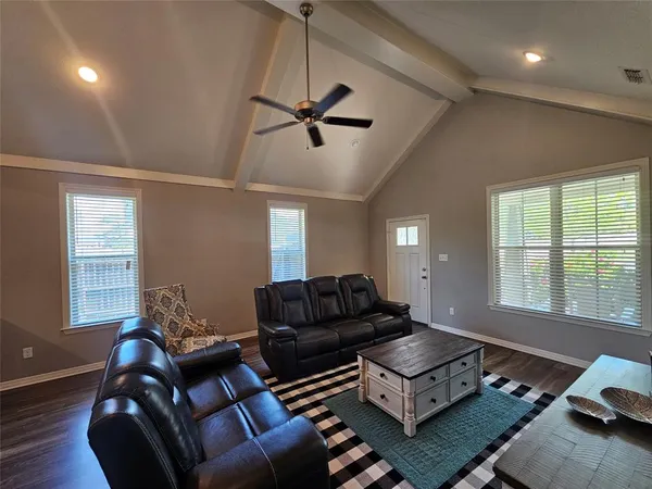 a living room with furniture ceiling fan and a window