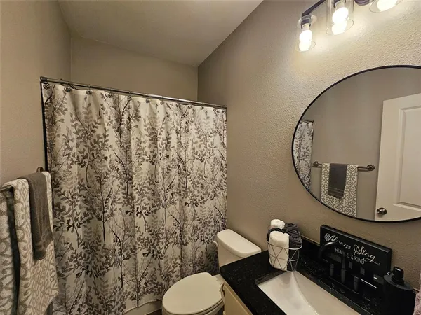 a bathroom with a toilet a sink and a mirror