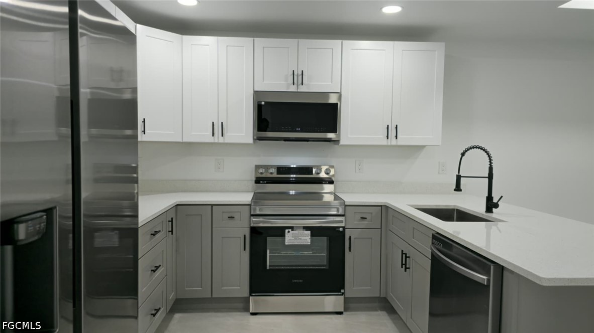 4429 26th Street Southwest Lehigh Acres, FL 33973 - Photo 3 of 16 a kitchen with cabinets stainless steel appliances and a sink