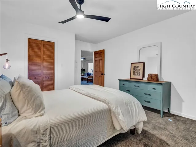 a bedroom with a bed and large windows