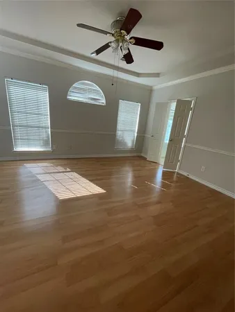 a view of an empty room with window and wooden floor