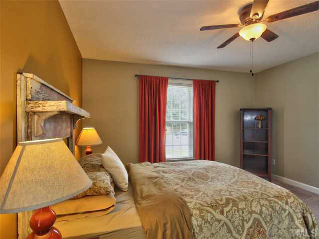 4309 Pillory Place Raleigh, NC 27616 - Photo 12 of 23 a bedroom with a bed and lamp