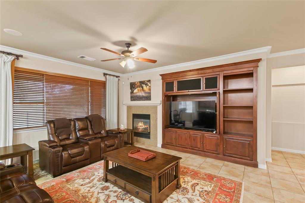 9116 Perimeter Street Denton, TX 76207 - Photo 16 of 26 a living room with furniture a flat screen tv and a fireplace