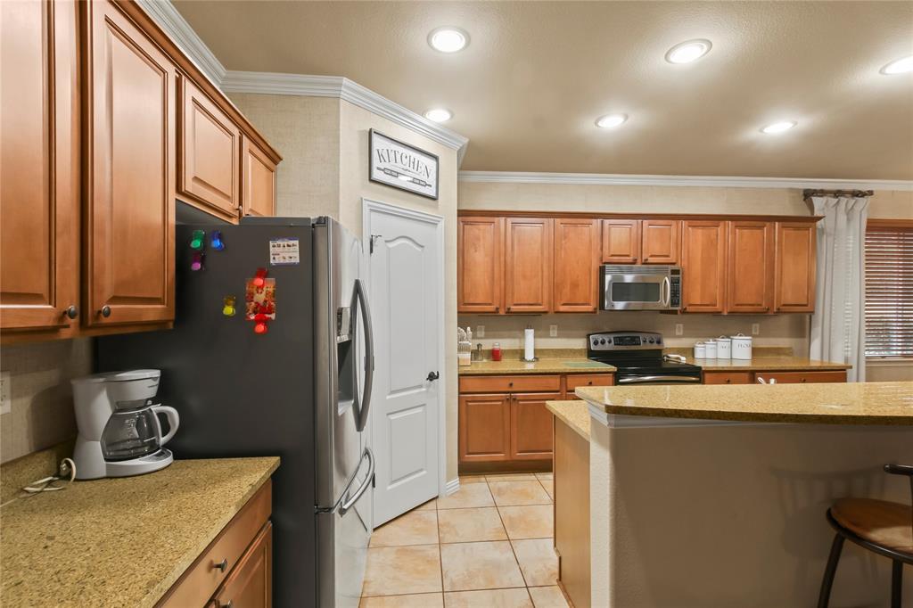9116 Perimeter Street Denton, TX 76207 - Photo 9 of 26 a kitchen with stainless steel appliances granite countertop a refrigerator a sink and white cabinets