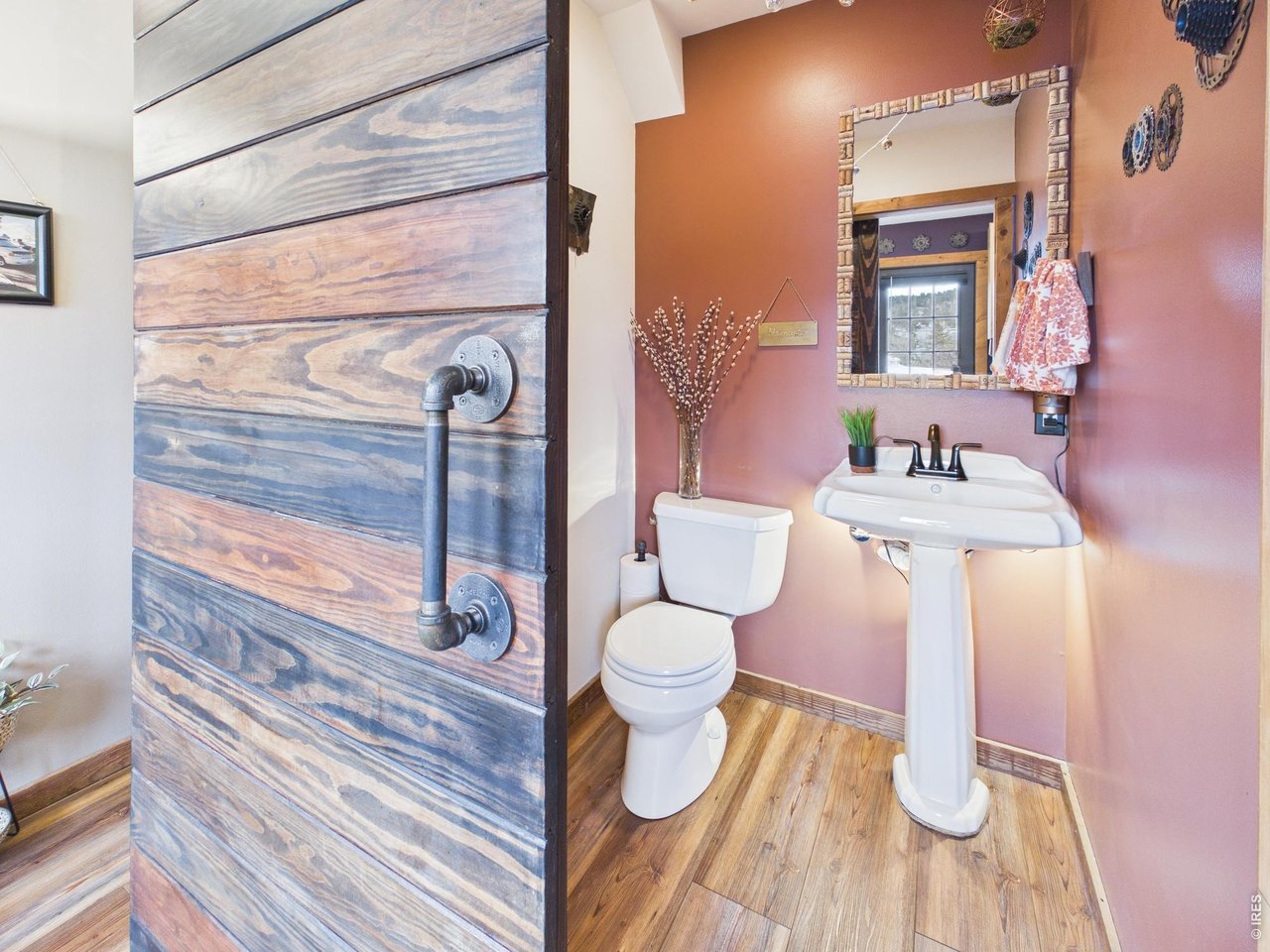 131 West Boulder Street Nederland, CO 80466 - Photo 15 of 46 Powder room on first floor, custom barn door, rustic flooring, designer lighting.