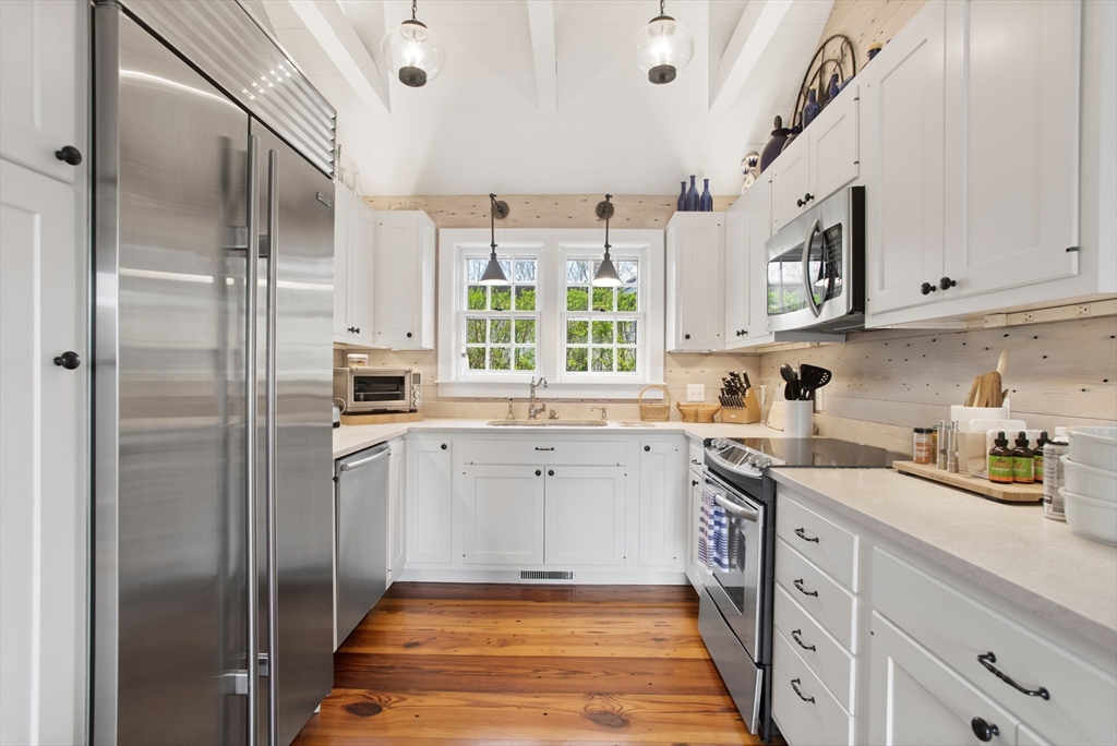 9 Lily Street Nantucket, MA 02554 - Photo 9 of 17 a kitchen with a sink cabinets stainless steel appliances and a window