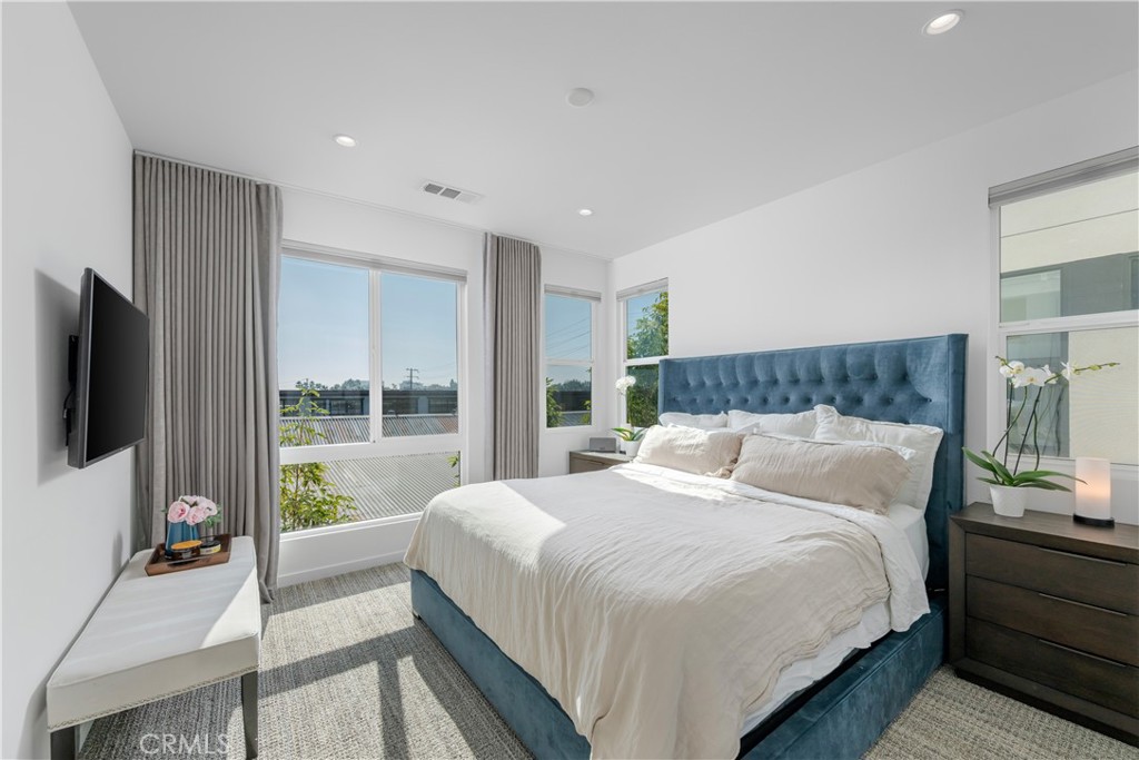 637 Cardiff Reef Costa Mesa, CA 92627 - Photo 16 of 27 a bedroom with a large bed and a flat screen tv