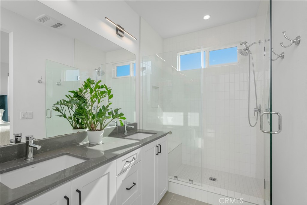 637 Cardiff Reef Costa Mesa, CA 92627 - Photo 18 of 27 a bathroom with a granite countertop sink a mirror and shower